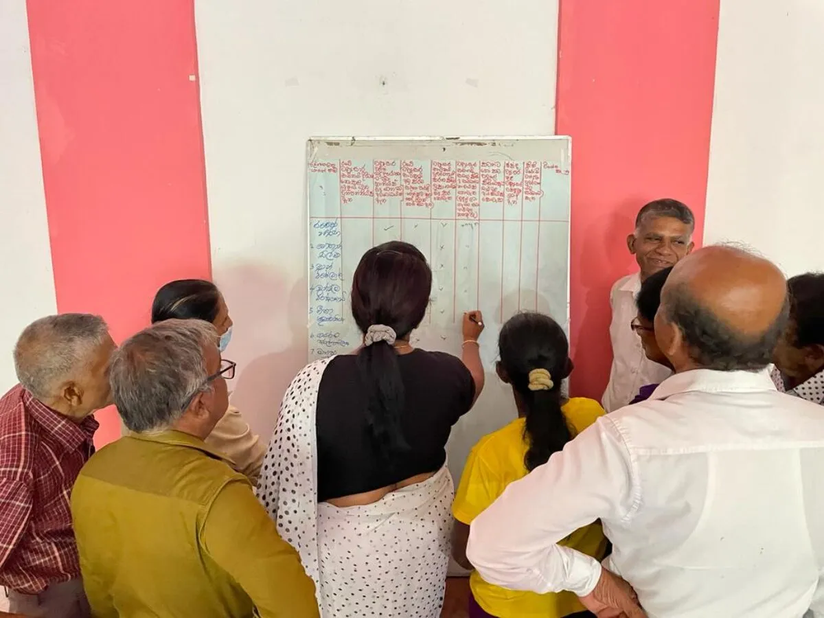 A group of RESET researchers gathered around a white board