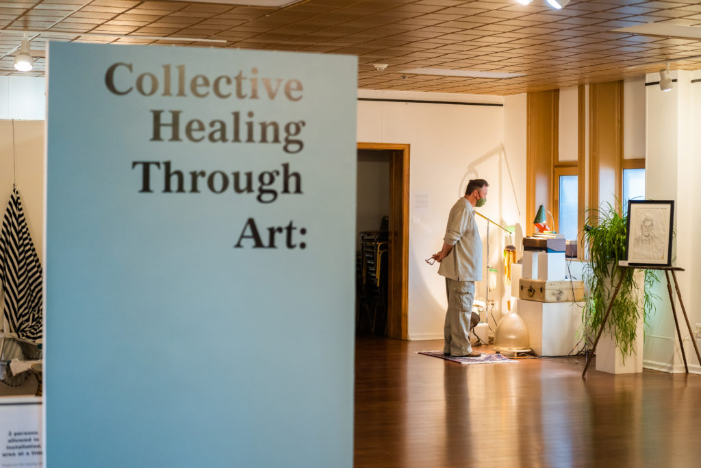 A person views overdose awareness art at the opening reception of the Collective Healing Through Art exhibit | Photo Credit: Valaurian Waller