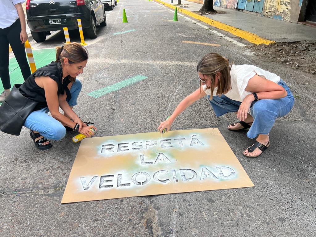 Road Safety volunteers paint a sign onto the road encouraging drivers to following the 20 kilometer per hour speed limit in a school zone in Buenos Aires, Argentina.